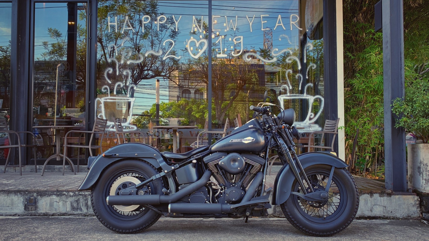รถ Harley-Davidson สีดำจอดหน้าร้านกาแฟ